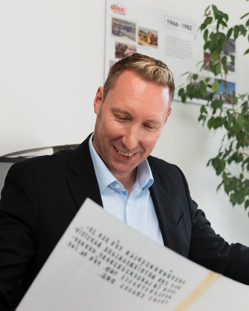 DI Franz Grassl, Baumeister und Geschäftsführer der Dipl.-Ing. Franz Grassl GmbH, liest lächelnd einen Plan